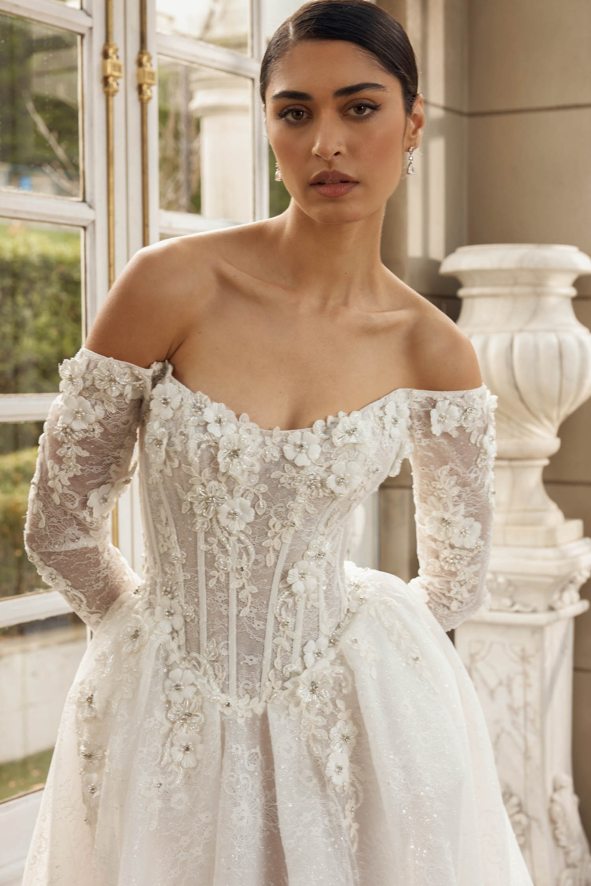 Trouwjurk met korsetlijfje Italia van Jeune by Madi Lane. Close-up van het off-shoulder design met 3D kanten bloemen.