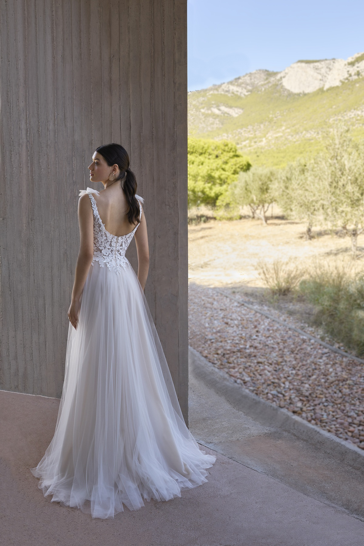 A-lijn trouwjurk L1178 van Orea sposa. Achteraanzicht met kanten lijfje, lage rug en een flowy tule rok met sleep.