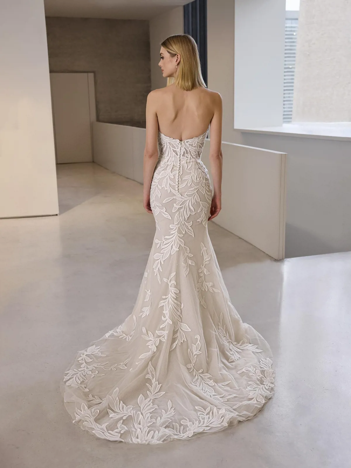 Trouwjurk met kant Debie van Pronovias, achteraanzicht. Strapless zeemeermin model met lage rug en picpac knoopjes.