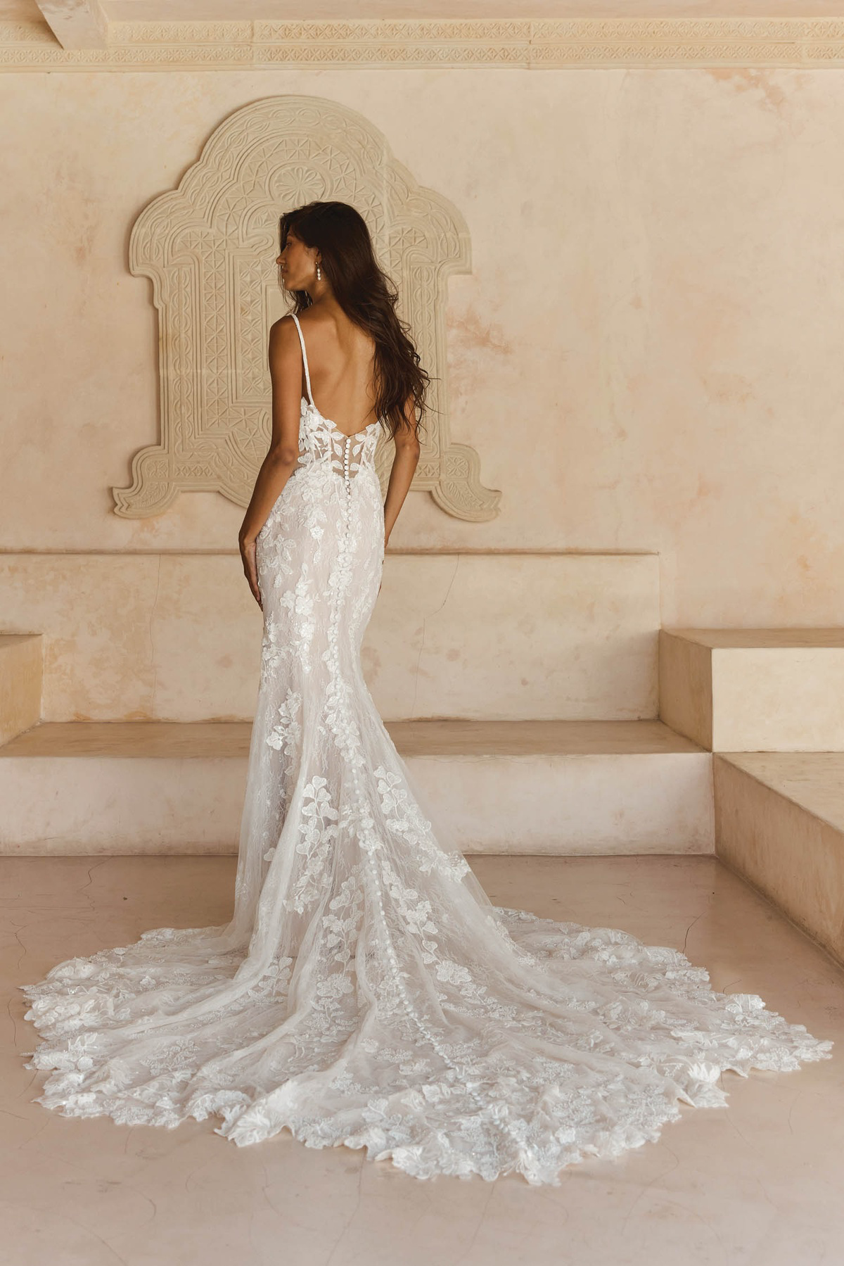 Zeemeermin trouwjurk Leigh van Madi Lane met lage rug. Achteraanzicht van de jurk met 3D kant en een lange kanten sleep.