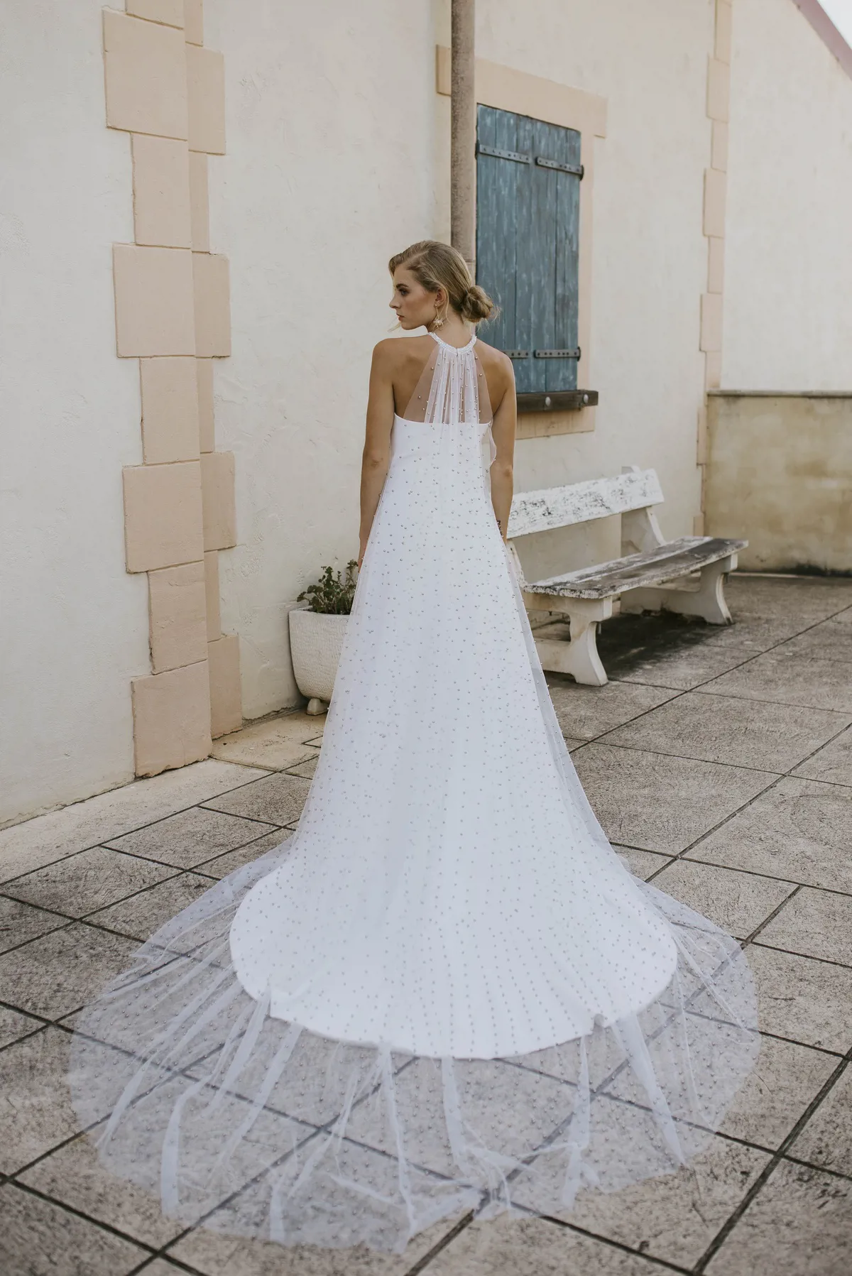 Trouwjurk met parels 8247 van Cizzy Bridal. Achteraanzicht van de A-lijn jurk met een see-through tule halter.