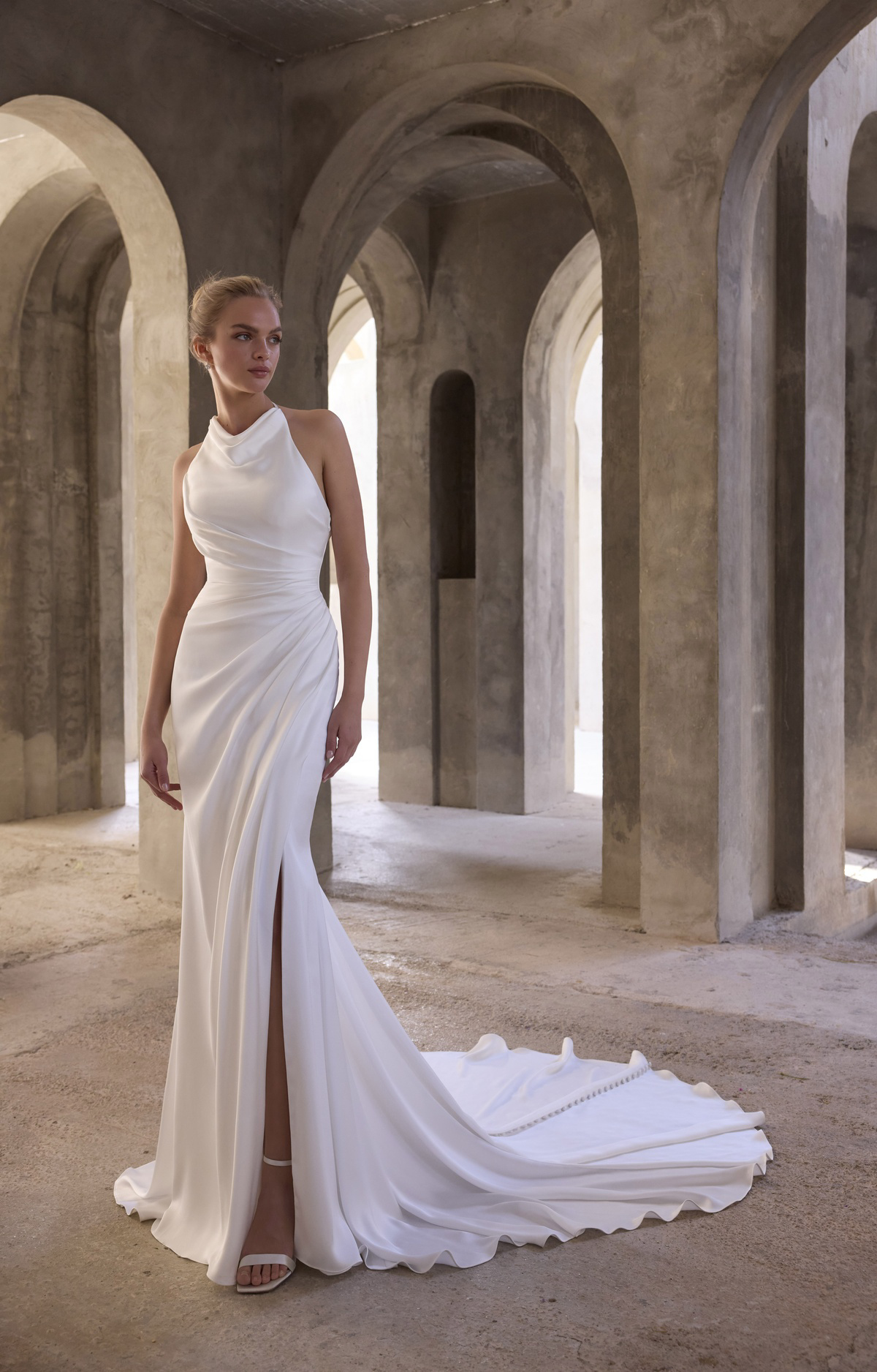 Trouwjurk satijn 2935 van Morilee, vooraanzicht met gedrapeerde halter, aangesloten pasvorm en een hoge split.