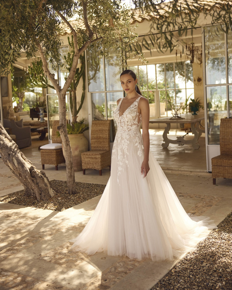 Trouwjurk met kant Grea van Modeca. Vooraanzicht A-lijn bruidsjurk met diepe V-hals en een luchtige, flowy tule rok.