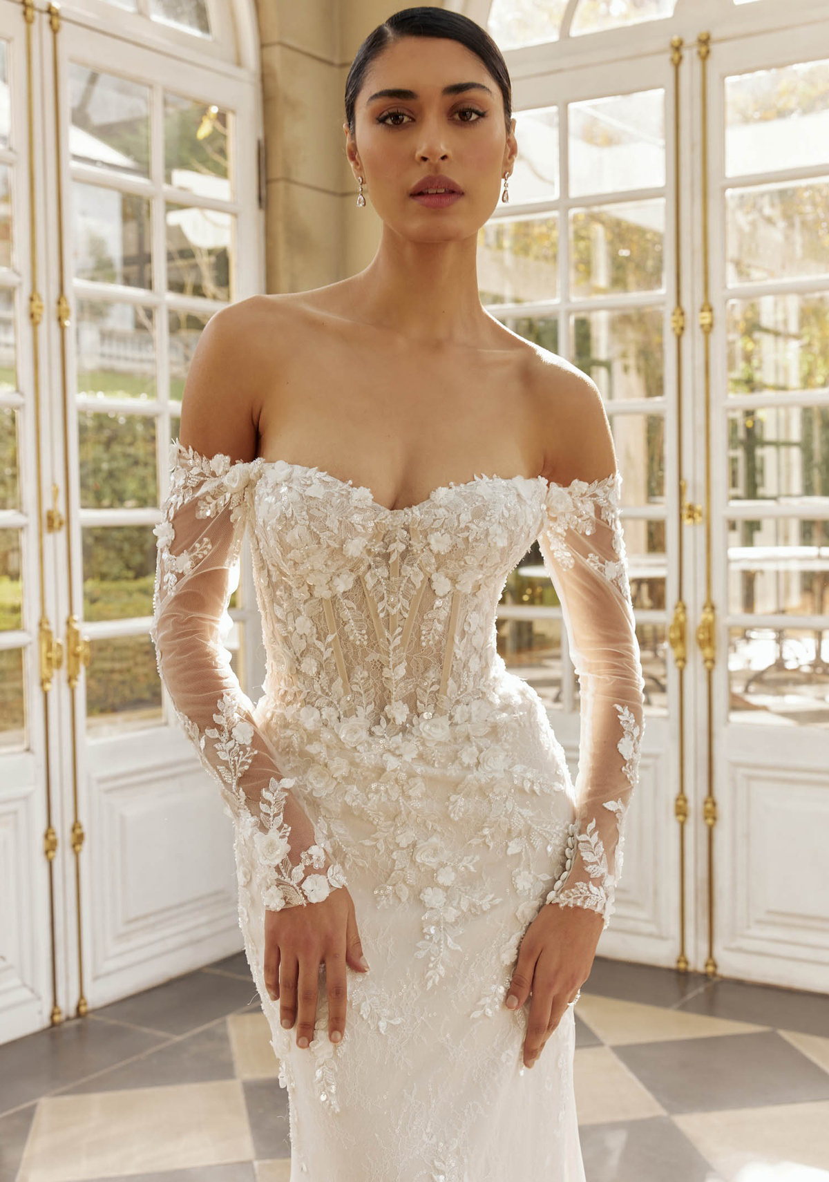 Off-shoulder trouwjurk Hartford met 3D kant en korsetlijfje. Vooraanzicht van Jeune by Madi Lane uit collectie van Bruidshuis Diana.