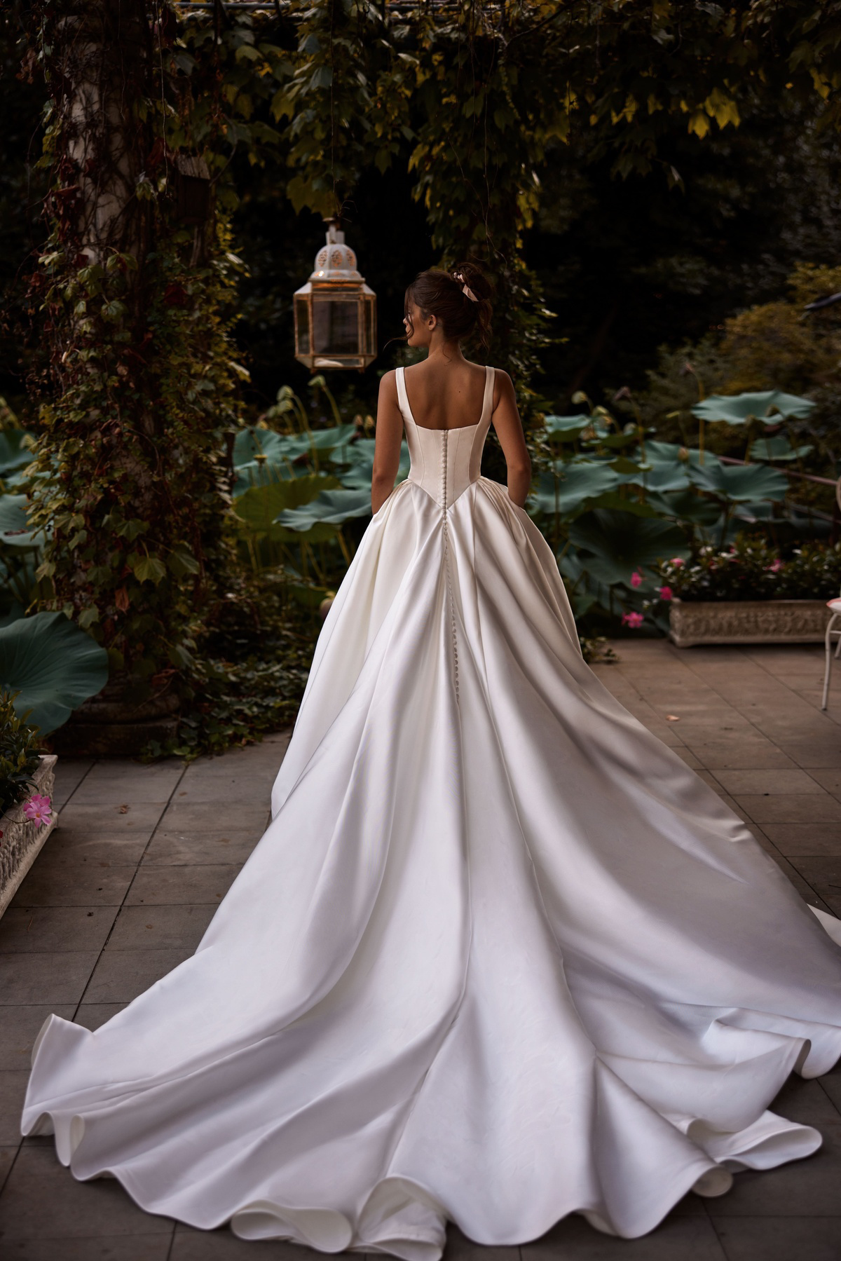 Trouwjurk met lange sleep Ermana van Milla Nova LR. Achteraanzicht van de satijnen jurk met picpac knoopjes.