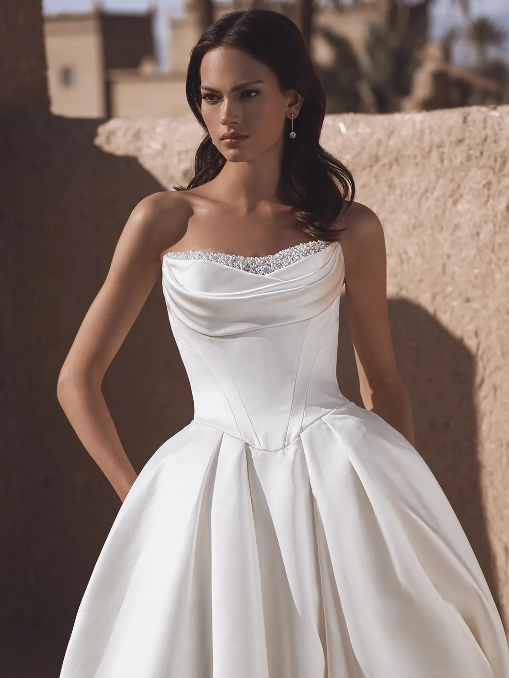 Satijnen trouwjurk Temina van Blue by Enzoani. Close-up van de strapless top met parels en klassiek korsetlijfje.
