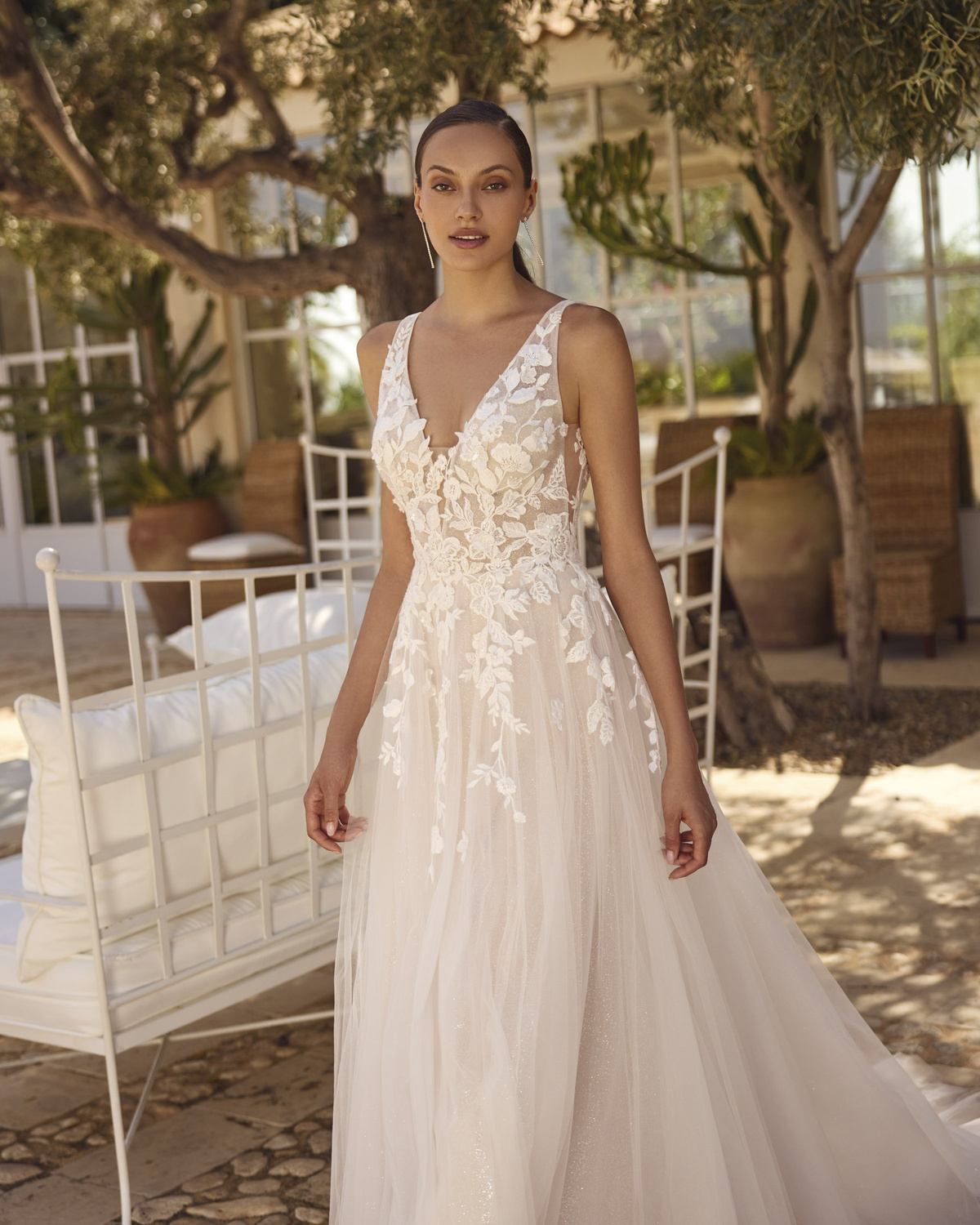 A-lijn trouwjurk Grea van Modeca met diepe V-hals. Vooraanzicht van het kanten lijfje en de flowy rok met glitters.
