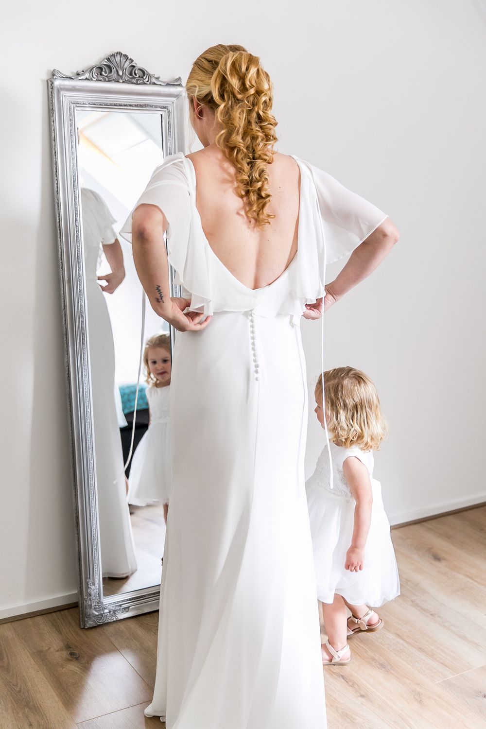 Nienke in trouwjurk voor een spiegel