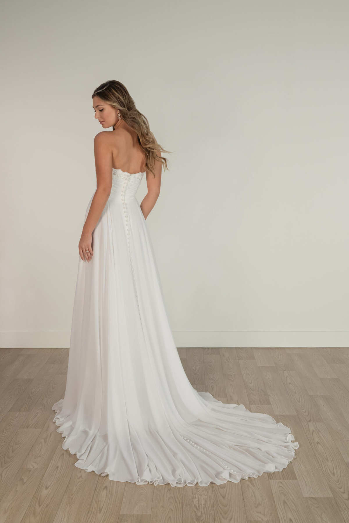 Strapless A-lijn trouwjurk Stella York 8145. Achteraanzicht met picpac knoopjes en een romantische, flowy chiffon rok.