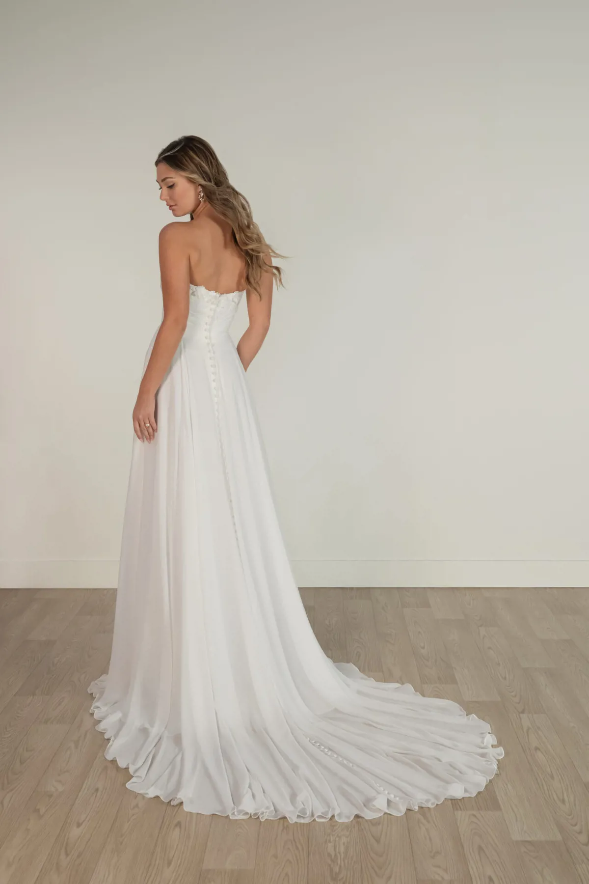 Strapless A-lijn trouwjurk Stella York 8145. Achteraanzicht met picpac knoopjes en een romantische, flowy chiffon rok.