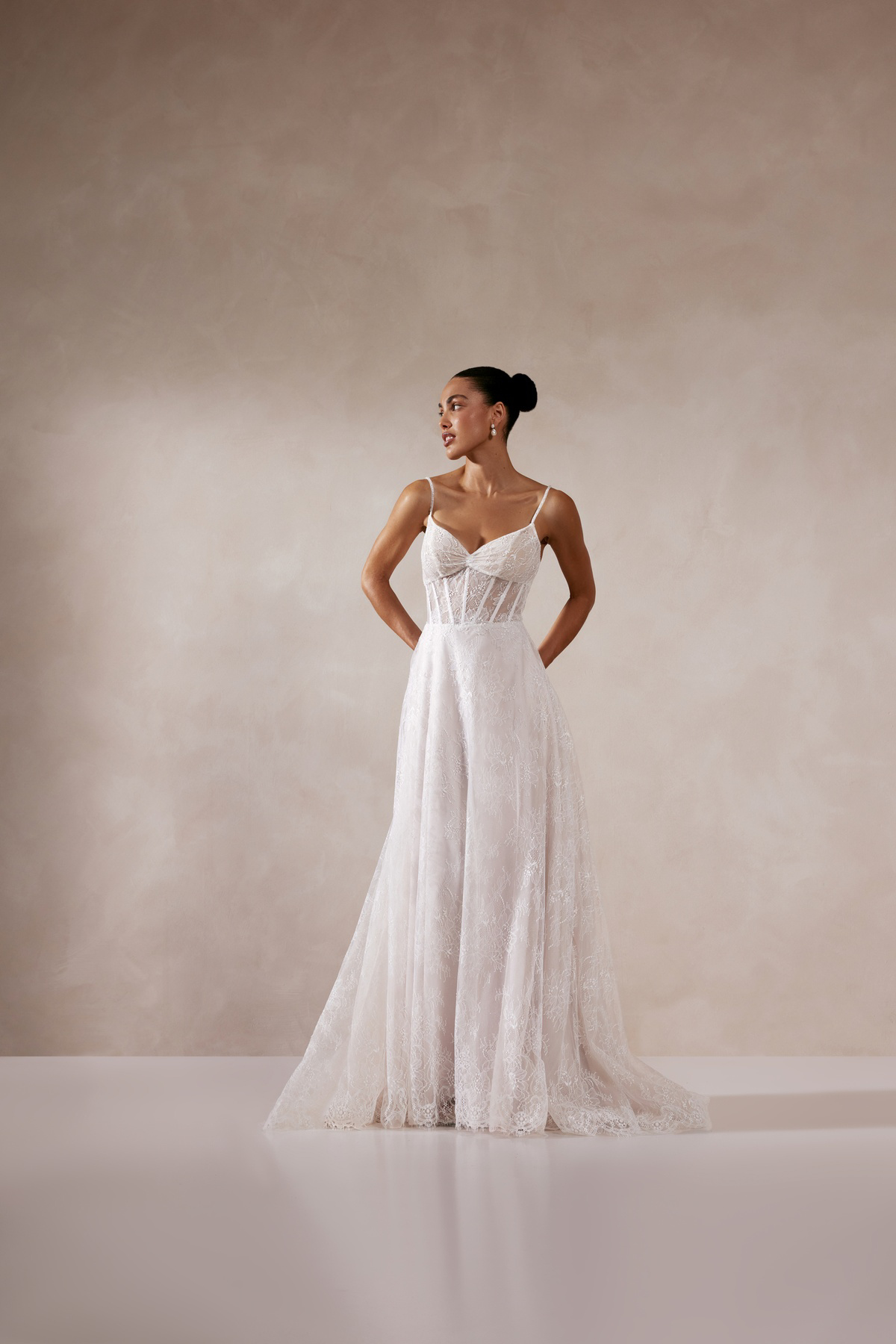 Kanten A-lijn trouwjurk Zia van Adore met see-through korsetlijfje en baleinen. Vooraanzicht van de romantische bruidsjurk.