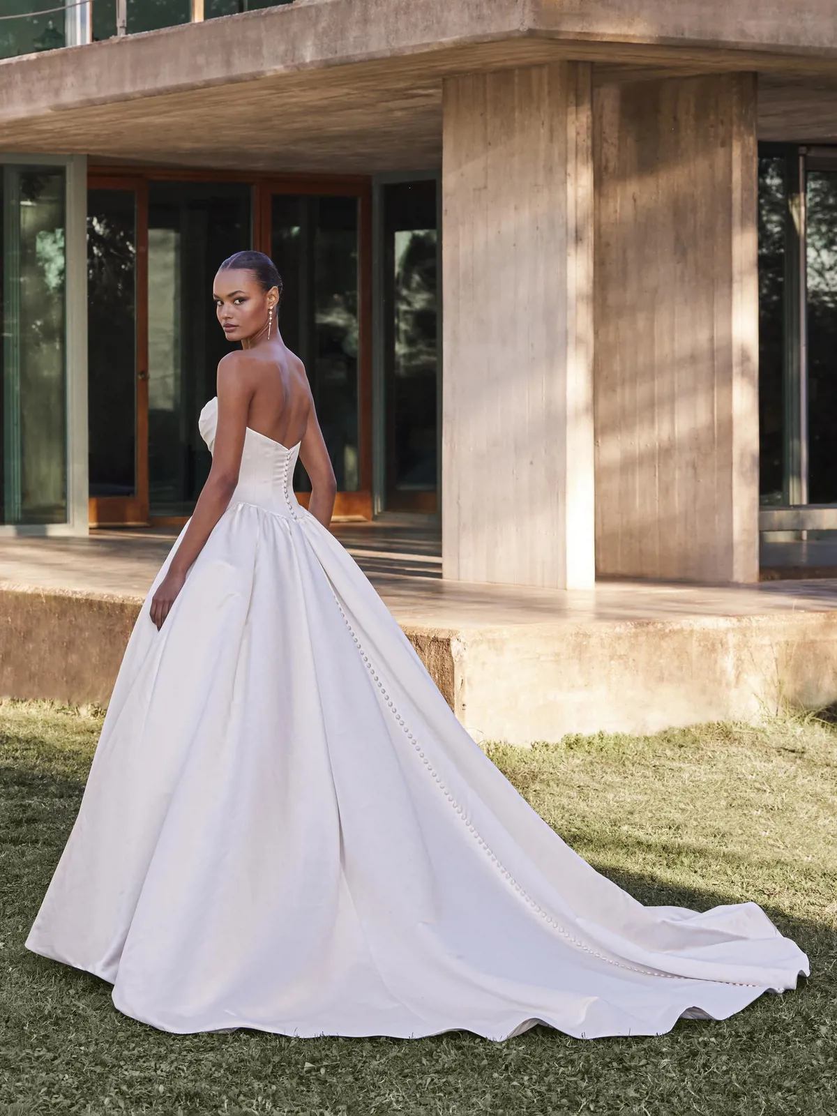 Prinsessenjurk Cillian van Pronovias, achteraanzicht. Klassieke strapless satijnen bruidsjurk met picpac knoopjes en lange sleep.