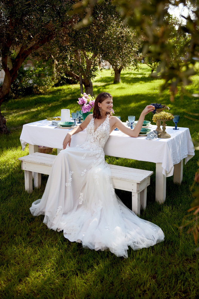 Bohemian A-lijn trouwjurk 66405 van Lillian West met kanten V-hals en flowy rok. Vooraanzicht in een zomerse tuin.