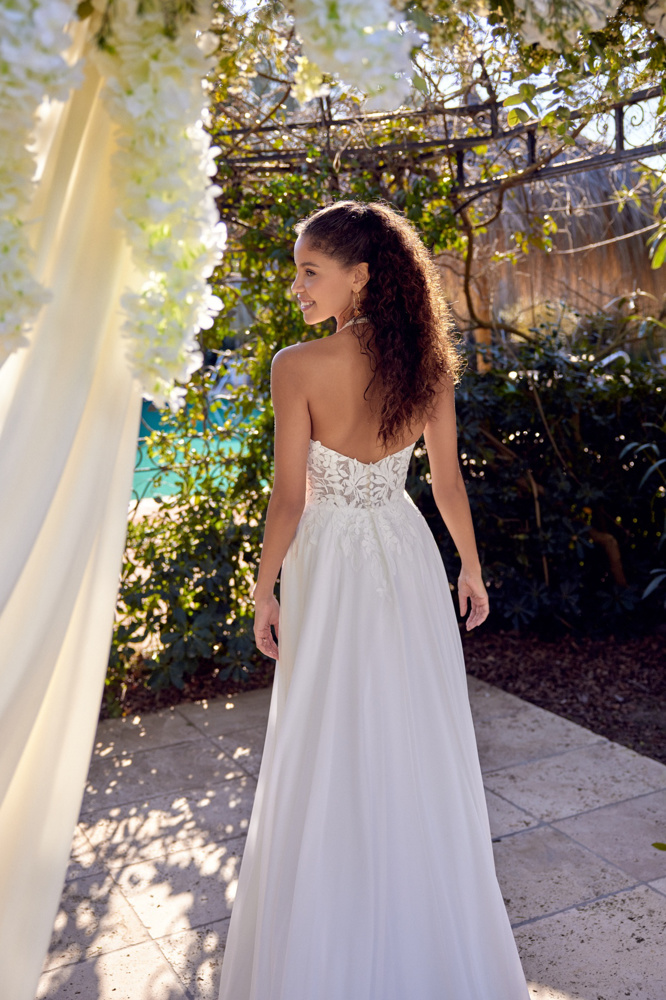 A-lijn trouwjurk 66425 van Lillian West. Achteraanzicht van het strapless kanten lijfje met lage rug en flowy chiffon rok.