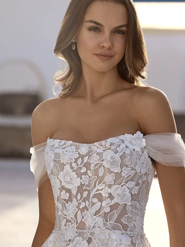 Off-shoulder trouwjurk Enola van Love by Enzoani. Close-up van het see-through lijfje met romantisch bloemenkant.