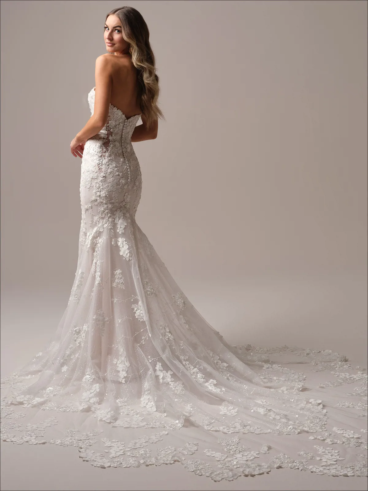 Zeemeermin trouwjurk Malone van Maggie Sottero met 3D kant. Achteraanzicht van de strapless jurk met lage rug en lange sleep.