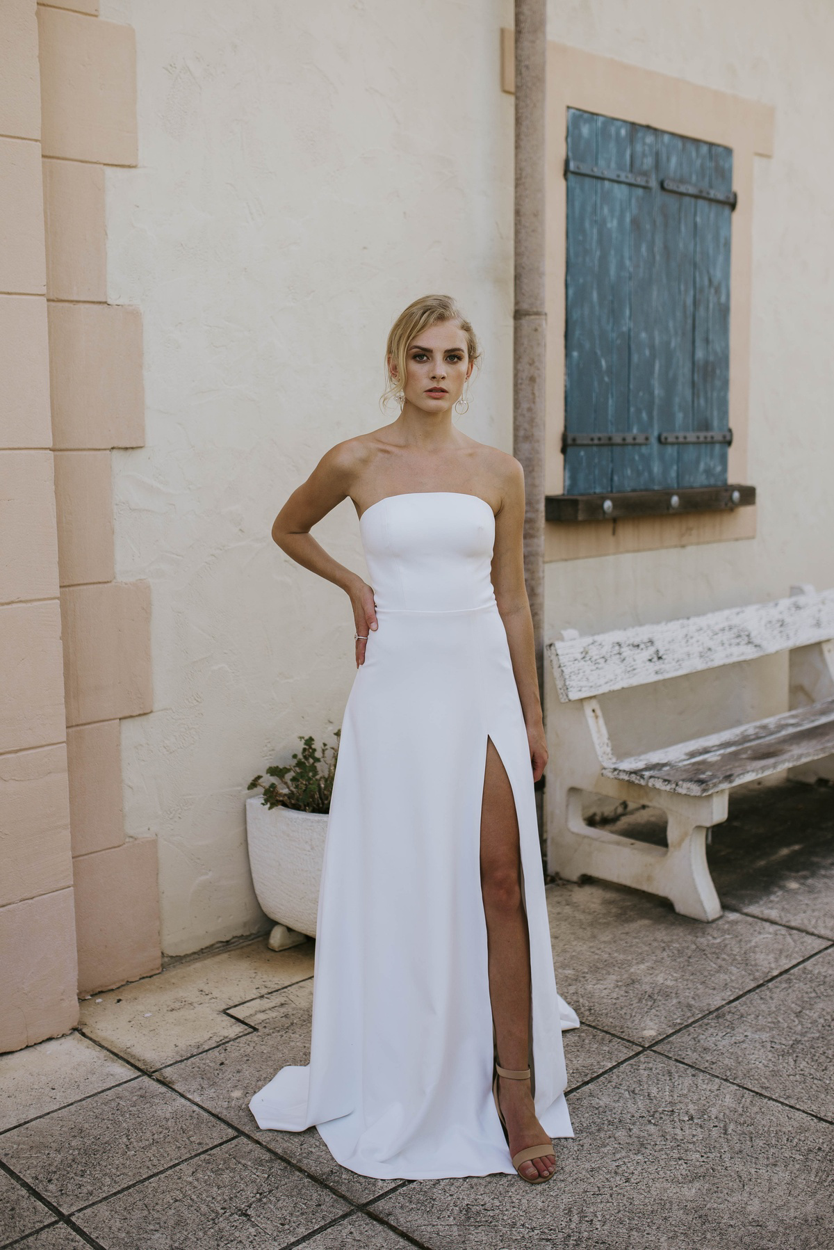 Strapless trouwjurk met split 8247 van Cizzy Bridal. Vooraanzicht van de minimalistische, rechtvallende bruidsjurk.