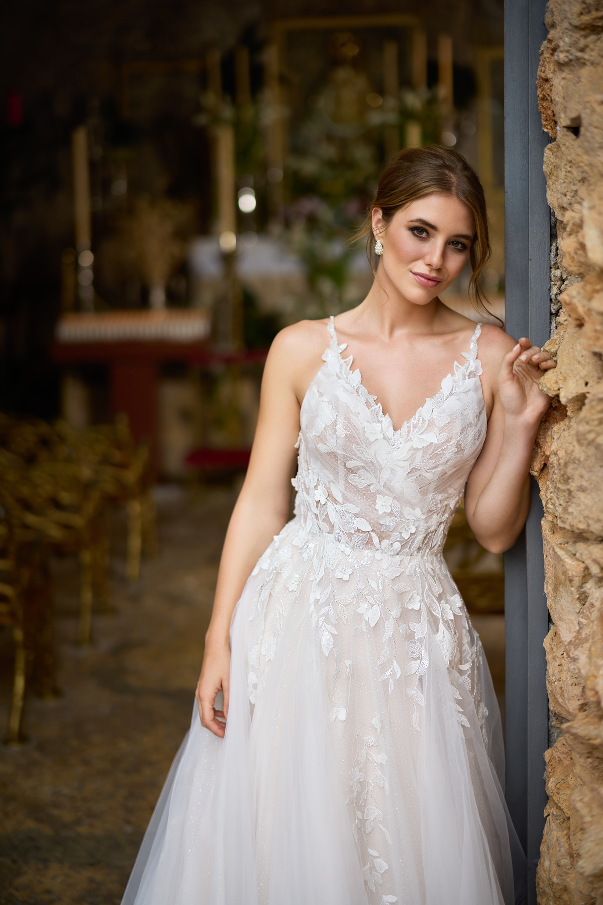 A-lijn trouwjurk 26217 van Tres chic. Close-up van het kanten lijfje met V-hals en schouderbandjes op een glitter tule rok.