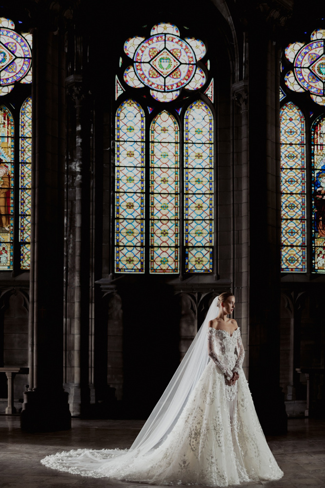 A-lijn trouwjurk Hannah van Zuhair Murad met 3D kant en off-shoulder lange mouwen, exclusief bij Bruidshuis Diana.