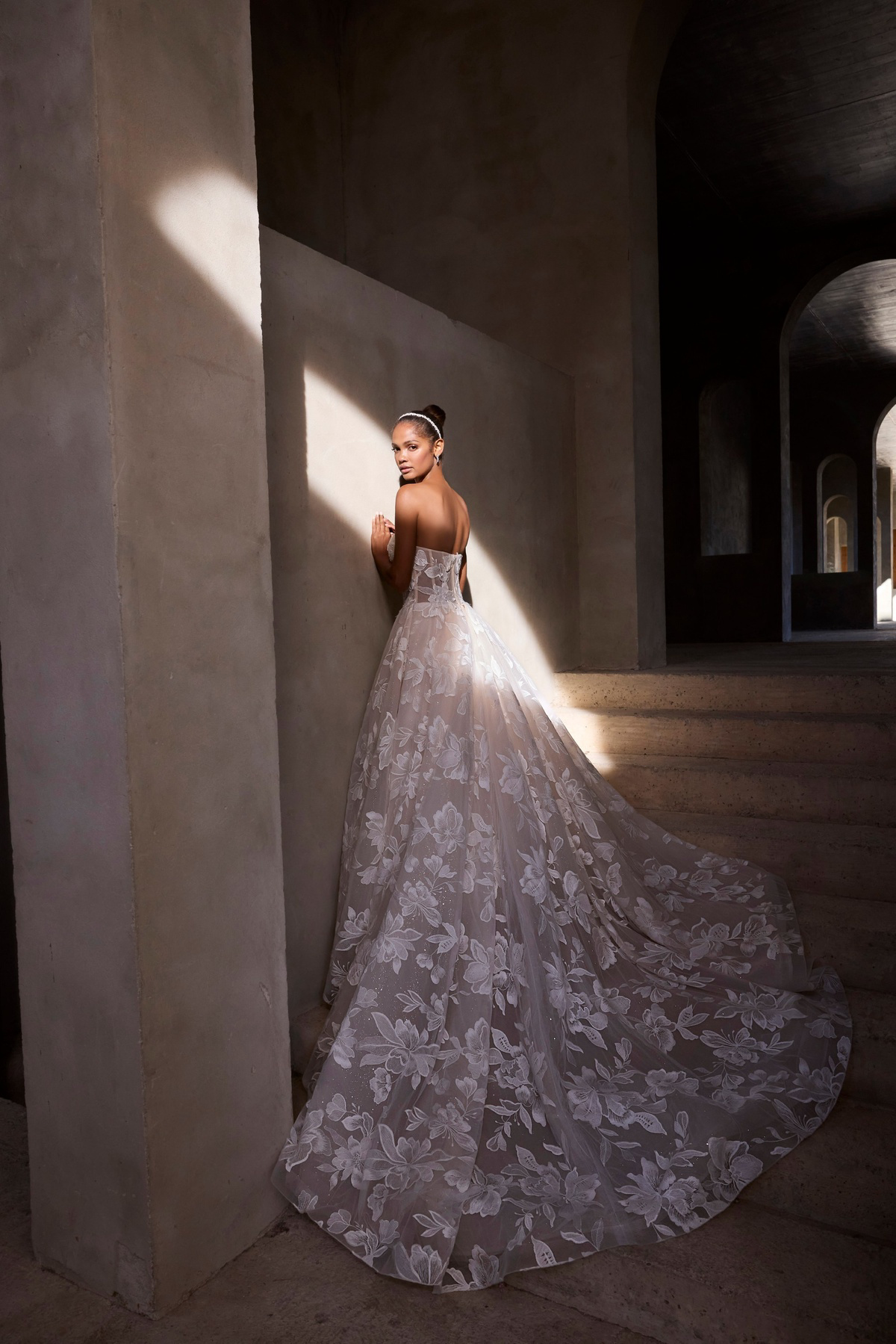 A-lijn trouwjurk 2937 van Morilee in achteraanzicht. De strapless jurk heeft een lange sleep met bloemenkant en glitter.