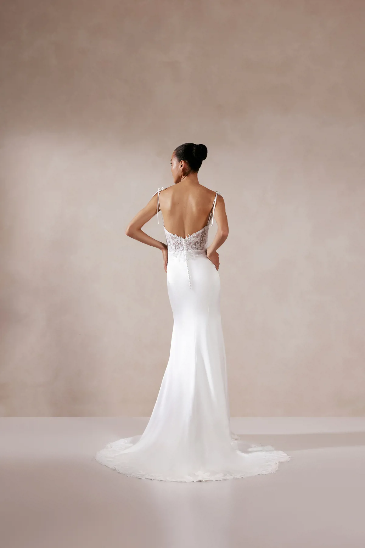Trouwjurk met lage rug Akemi van Adore, achteraanzicht met see-through kant en picpac knoopjes op de aangesloten rok.