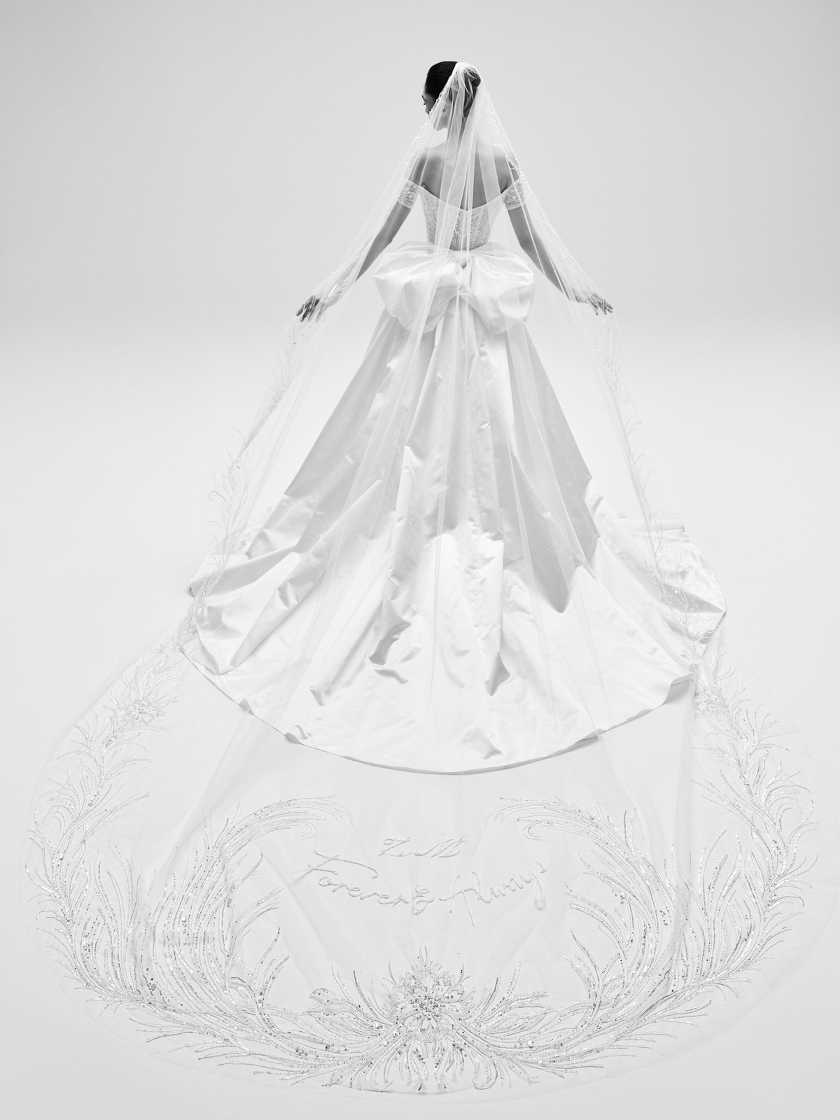 A-lijn trouwjurk Yara van Zuhair Murad, achteraanzicht. Satijnen bruidsjurk met grote strik en lange geborduurde sluier.